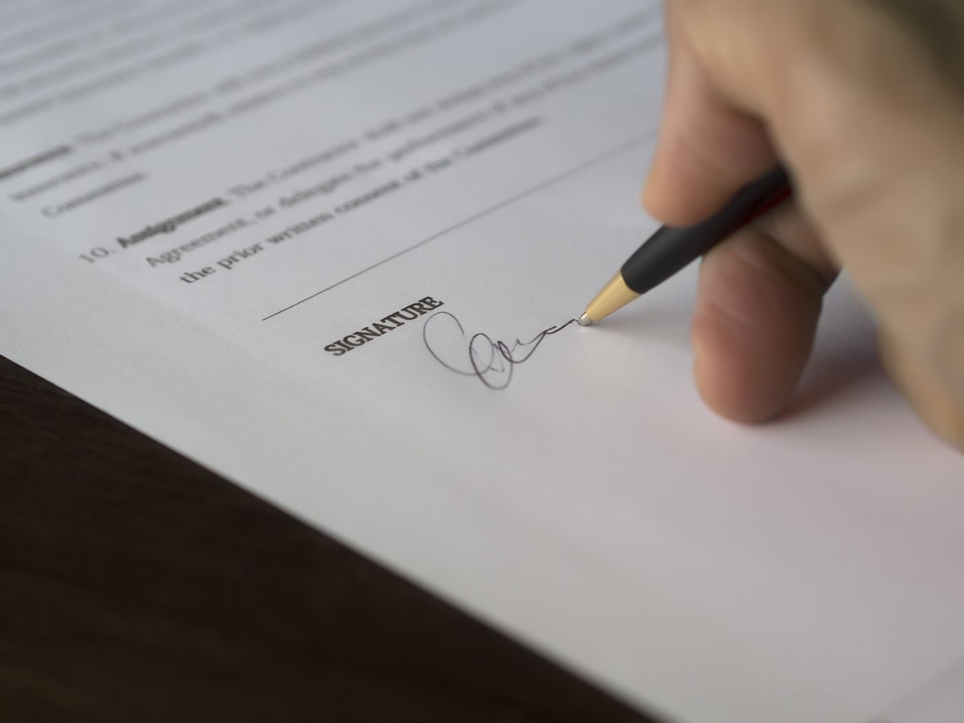 Main signant un document officiel au stylo